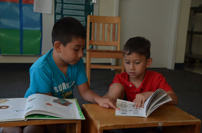 Two young children looking at books